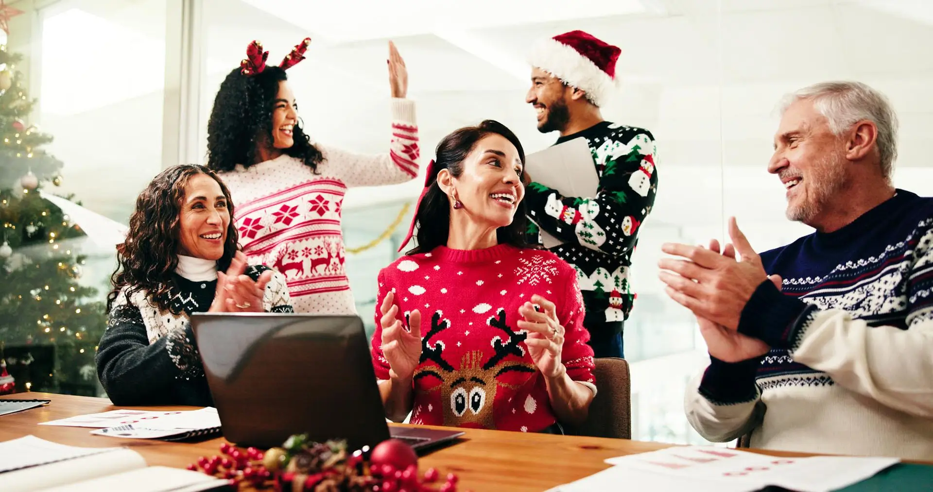 Employees wearing Christmas jumpers celebrating with their Christmas marketing tips
