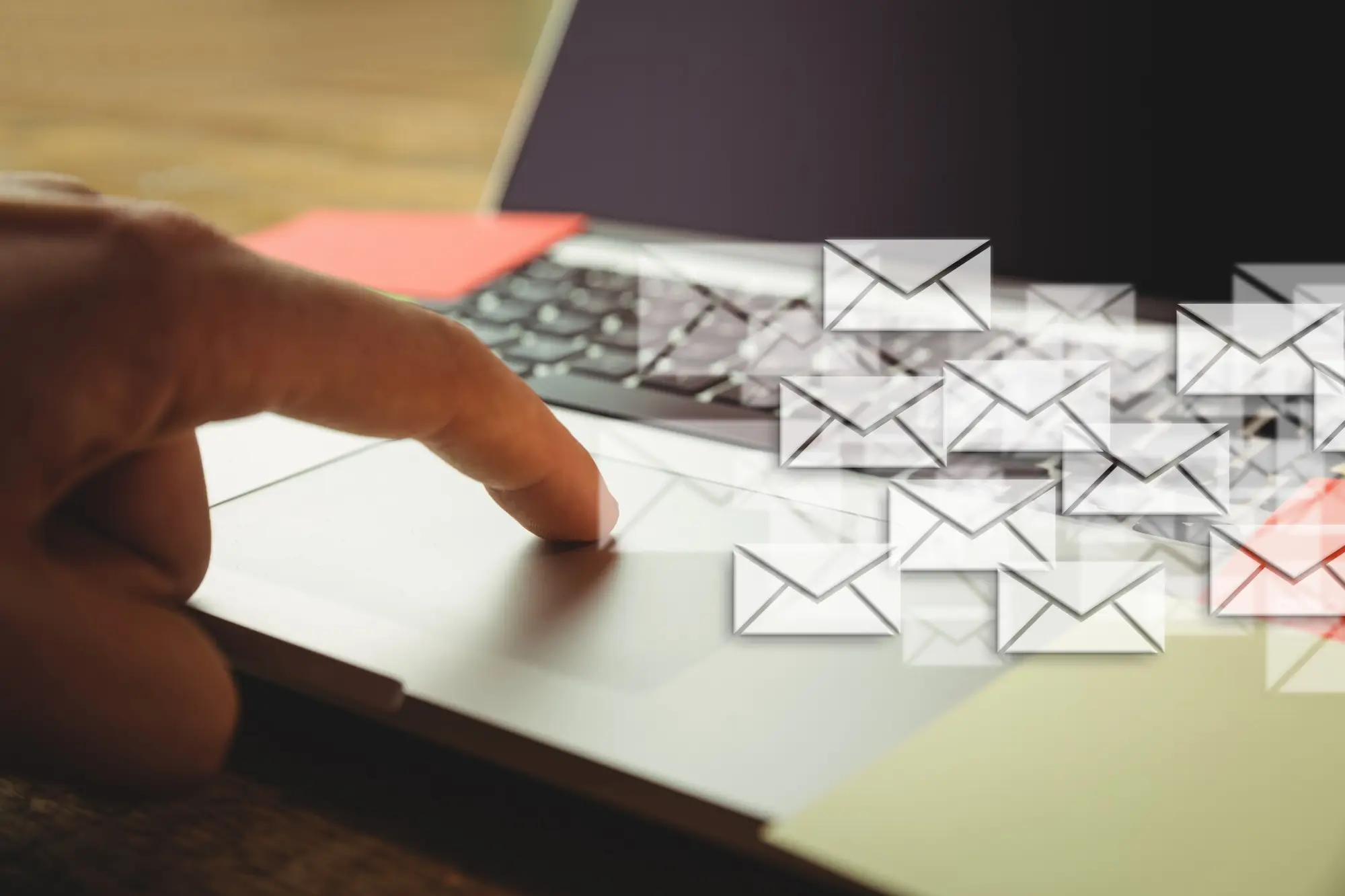 Close-up of someone using a laptop with email icons